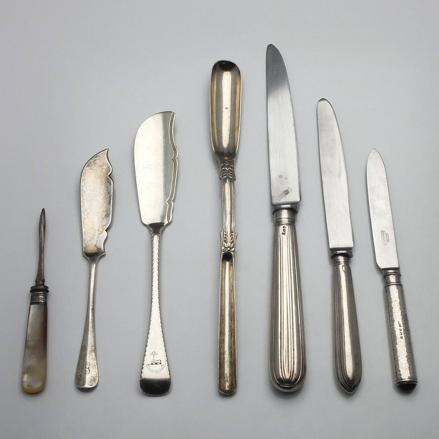 'Sterling Silver Marrow Scoop, Two Sterling Fish Servers, Three Sterling Handled Knives and a Mother of Pearl and Sterling Sewing Hook'