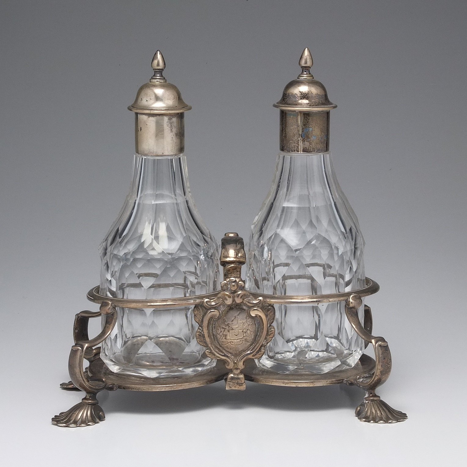 'George III Crested Sterling Silver and Cut Crystal Two Bottle Oil and Vinegar Stand Robert Calderwood Dublin Circa 1760'
