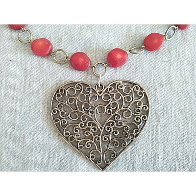 Red beaded necklace with filigree heart pendant with heart shaped clasp and matching earrings