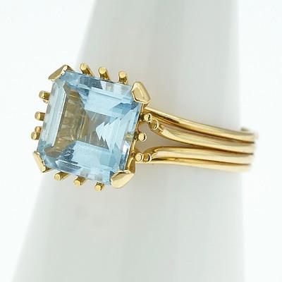 18ct Yellow Gold Ring With Square Emerald Cut Aquamarine Set With Four Claws in a Wire Basket Setting