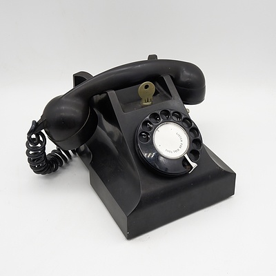 A Black Bakelite Telephone with Key Lock and Modern Wall Socket Attachment