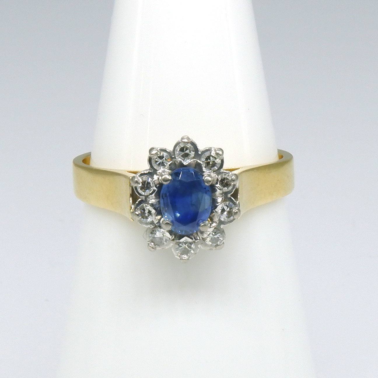 '18ct Yellow and White Gold Ring, Oval Cluster with Centre Medium Blue Ceylonese Type Sapphire and Ten Single Cut Diamonds in Claw Setting'