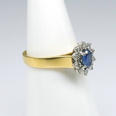 18ct Yellow and White Gold Ring, Oval Cluster with Centre Medium Blue Ceylonese Type Sapphire and Ten Single Cut Diamonds in Claw Setting