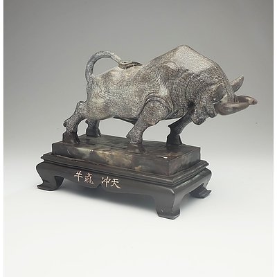 A Chinese Cast Resin Statue of a Charging Buffalo on a Wooden Stand
